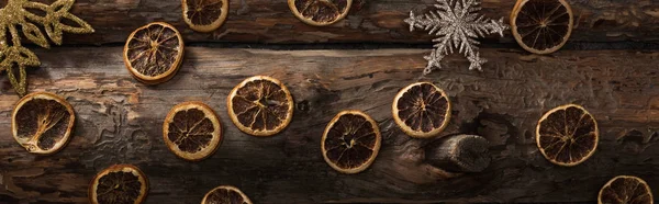 Top view of dried citrus slices and decorative snowflakes on wooden background, panoramic shot — Stock Photo