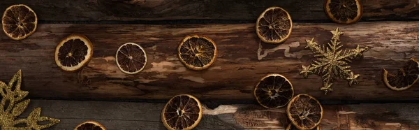 Top view of dried citrus slices and decorative snowflakes on wooden background, panoramic shot — Stock Photo