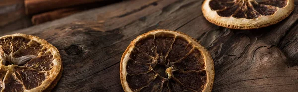 Panoramic shot of dried citrus slices on wooden background — Stock Photo