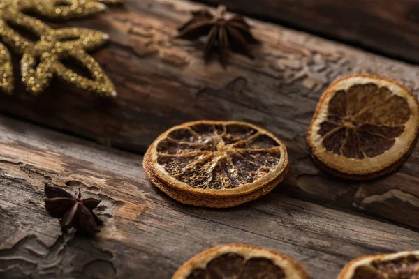 Fatias de citrinos secos com anis e floco de neve decorativo no fundo de madeira — Fotografia de Stock