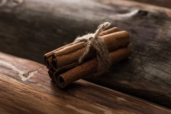 Vista de cerca de palos de canela sobre fondo de madera - foto de stock