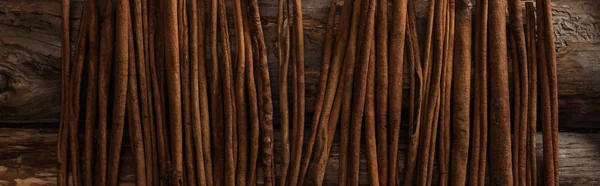 Top view of cinnamon sticks on wooden background, panoramic shot — Stock Photo