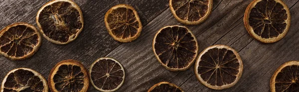 Top view of dried citrus slices on wooden brown surface, panoramic shot — Stock Photo