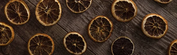 Top view of dried citrus slices on wooden brown surface, panoramic shot — Stock Photo