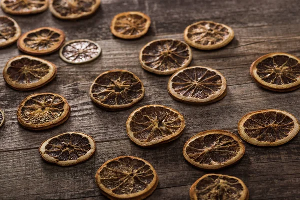 Сушені цитрусові скибочки на дерев'яній коричневій поверхні — стокове фото
