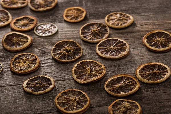 Tranches d'agrumes séchées sur une surface brune en bois — Photo de stock