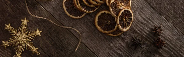 Top view of thread,snowflake and dried citrus slices on wooden background, panoramic shot — Stock Photo