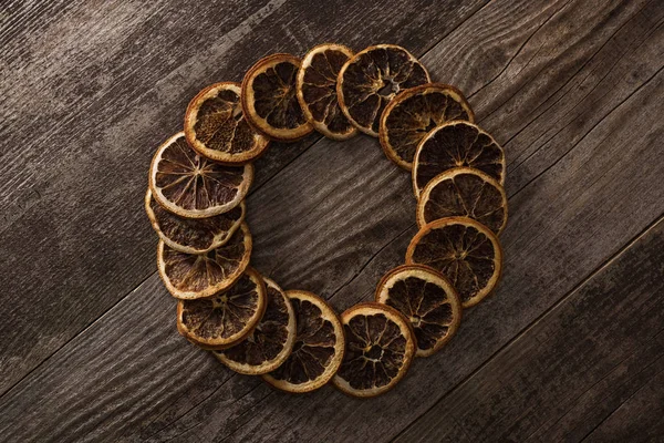 Кругла рамка сушених апельсинових скибочок на дерев'яному фоні — стокове фото