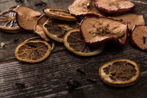 Сушені цитрусові та яблучні скибочки на дерев'яній поверхні — стокове фото
