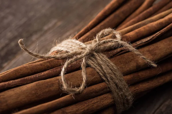 Vista de cerca de palos de canela en racimo en la mesa rústica de madera - foto de stock