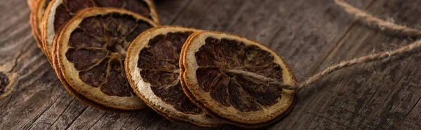 Fatias de laranja secas no fio na mesa de madeira, tiro panorâmico — Fotografia de Stock