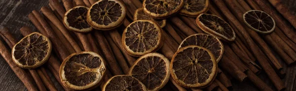 Fatias de laranja secas e canela no fundo de madeira, tiro panorâmico — Fotografia de Stock
