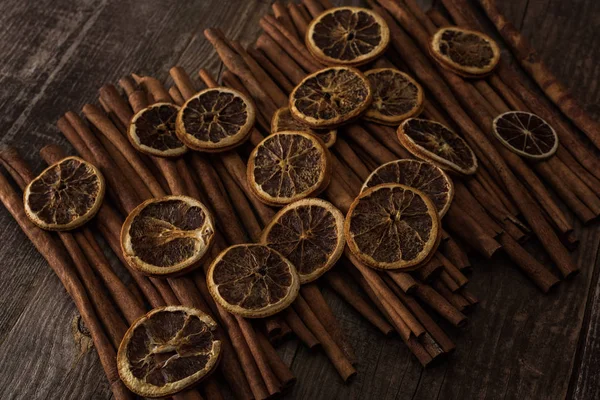 Rodajas de naranja seca y canela sobre fondo de madera - foto de stock