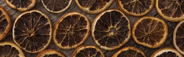Vista superior de rebanadas de naranja seca sobre fondo de madera, plano panorámico - foto de stock