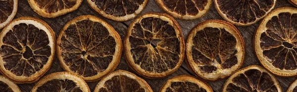 Top view of dried orange slices on wooden background, panoramic shot — Stock Photo