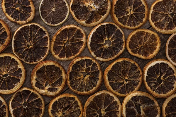 Top view of dried orange slices on wooden background — Stock Photo