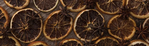 Top view of dried orange slices on wooden background with anise, panoramic shot — Stock Photo