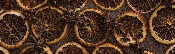 Top view of dried orange slices on wooden background with anise, panoramic shot — Stock Photo