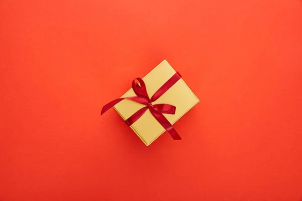 Top view of golden gift box on red background — Stock Photo