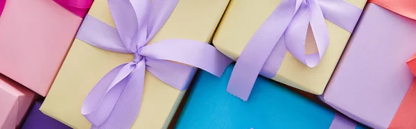 Top view of multicolored gift boxes with ribbons and bows, panoramic shot — Stock Photo