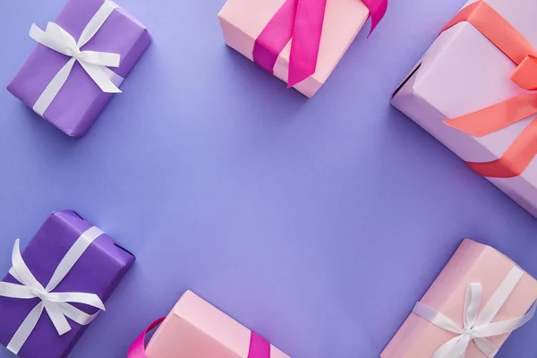 Top view of colorful presents with bows on purple background with copy space — Stock Photo