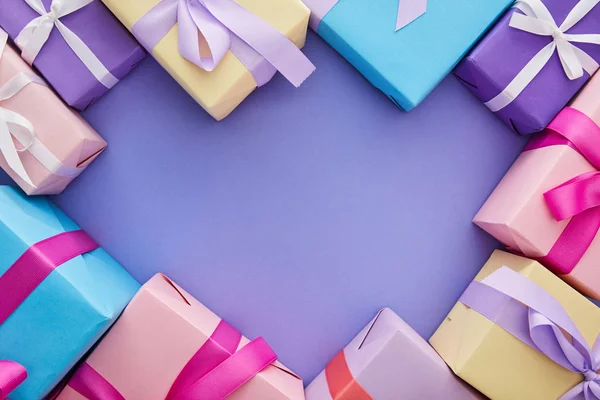 Top view of colorful presents with bows on purple background with copy space — Stock Photo