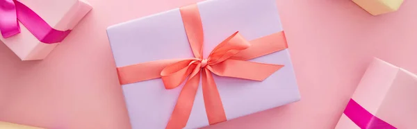 Top view of colorful gift boxes with ribbons and bows on pink background, panoramic shot — Stock Photo