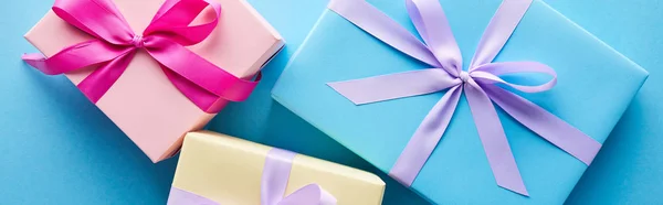 Vue de dessus des boîtes-cadeaux colorées sur fond bleu, panoramique — Photo de stock