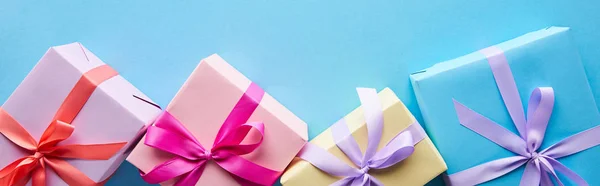 Top view of colorful gift boxes on blue background, panoramic shot — Stock Photo
