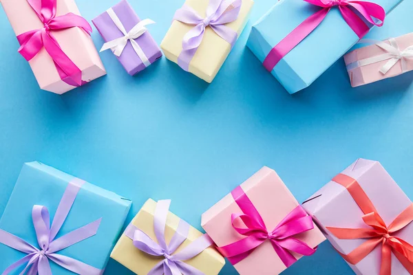 Top view of colorful gift boxes on blue background with copy space — Stock Photo