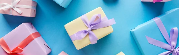 Top view of colorful gift boxes on blue background, panoramic shot — Stock Photo