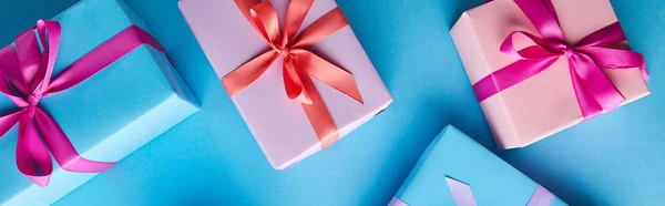 Top view of colorful gift boxes on blue background, panoramic shot — Stock Photo