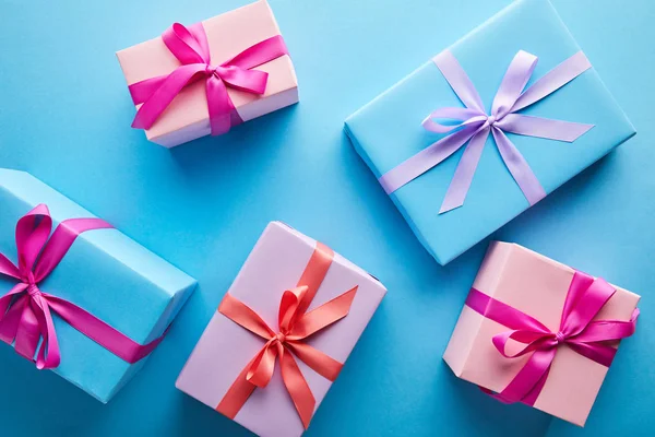 Vista superior de coloridas cajas de regalo sobre fondo azul - foto de stock