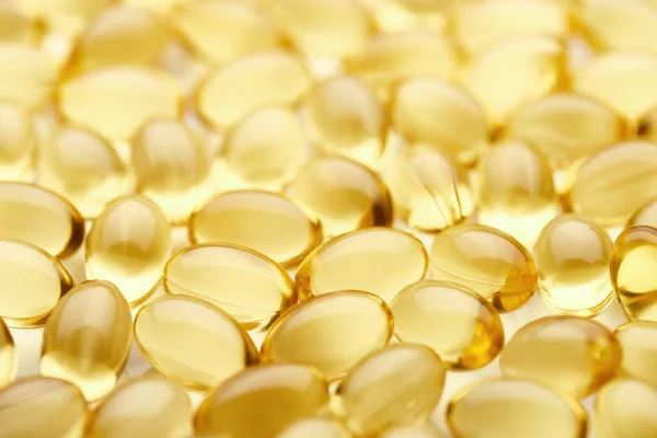 Close up view of golden fish oil capsules — Stock Photo