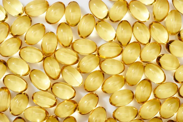 Top view of golden fish oil capsules on white background — Stock Photo