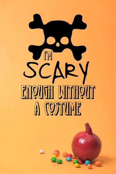 Calabaza de Halloween rojo pintado con dulces sobre fondo naranja con i am scary enough without a costume illustration - foto de stock