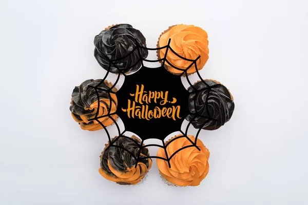 Vista superior de deliciosos cupcakes de Halloween em círculo com teia de aranha e ilustração feliz Halloween isolado no branco — Fotografia de Stock