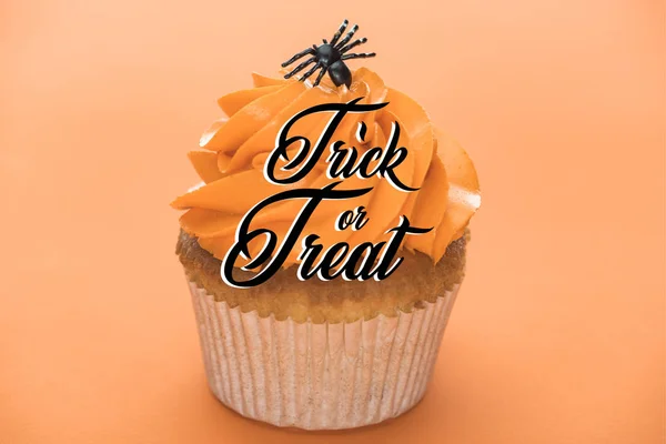 Scary Halloween cupcake with black spider and trick or treat illustration on orange background — Stock Photo