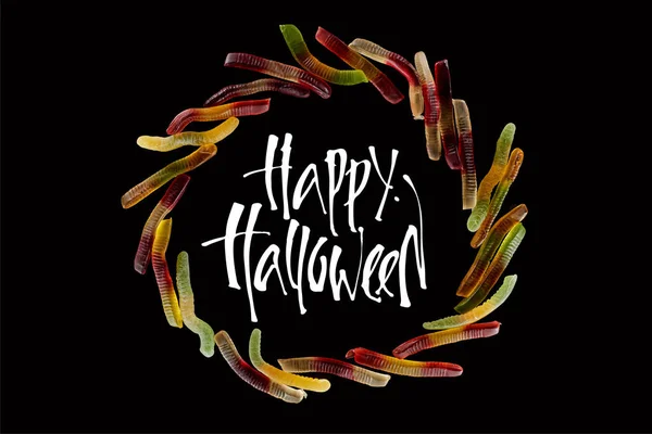 Top view of round frame made of colorful gummy worms isolated on black with happy Halloween illustration — Stock Photo