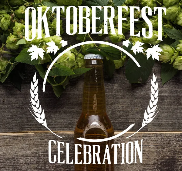 Vista superior de la cerveza fresca en botella con lúpulo verde en la superficie de madera con ilustración celebración Oktoberfest — Stock Photo