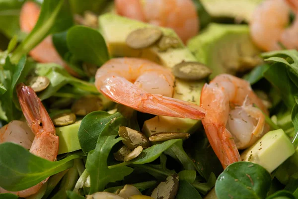 Close up view of fresh green salad with pumpkin seeds, shrimps and avocado — Stock Photo