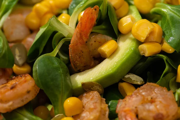 Vista de perto da salada verde fresca com sementes de abóbora, milho, camarões e abacate — Fotografia de Stock