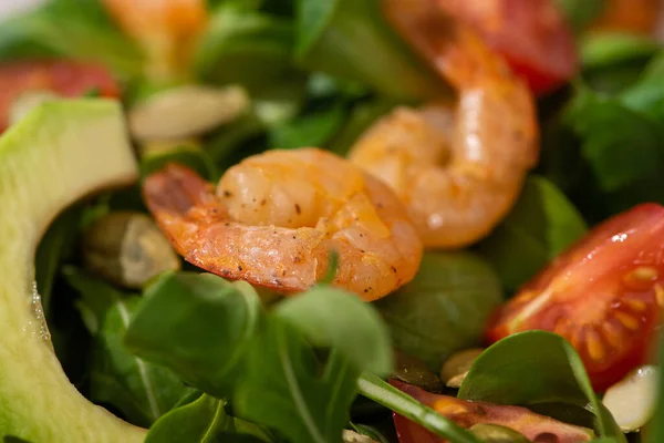 Close up view of fresh green salad with pumpkin seeds, cherry tomatoes, shrimps and avocado — Stock Photo