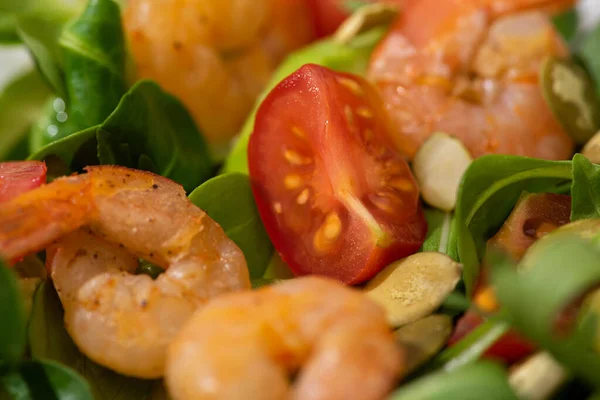 Nahaufnahme von frischem grünen Salat mit Kürbiskernen, Kirschtomaten, Garnelen und Avocado — Stockfoto