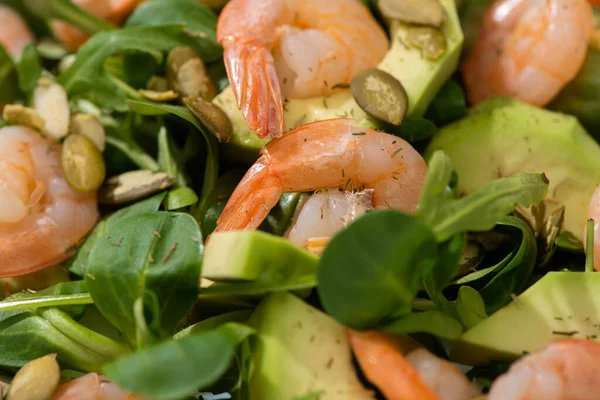 Close up view of fresh green salad with pumpkin seeds, shrimps and avocado — Stock Photo