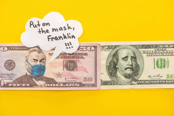 Вид зверху банкнот з намальованою медичною маскою та виразами обличчя біля бульбашки мовлення на жовтому фоні — стокове фото