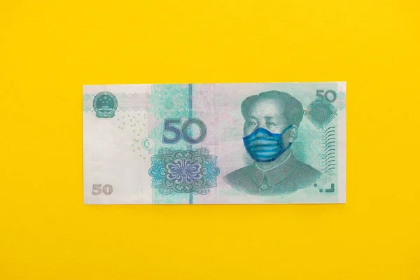 Вид зверху банкноти з намальованою медичною маскою на жовтому фоні — стокове фото