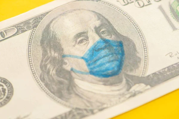 Vista de cerca del billete de dólar con máscara médica dibujada sobre fondo amarillo - foto de stock