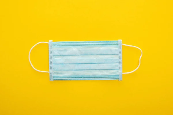 Top view of medical mask on yellow background — Stock Photo