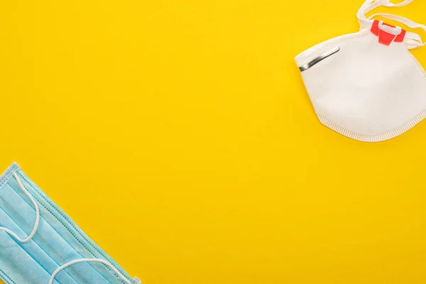 Vista dall'alto di maschere mediche e di sicurezza su sfondo giallo — Foto stock